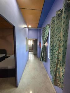 un pasillo que conduce a una habitación con paredes moradas en Roop Amrit Guest House , Agartala, en Agartala