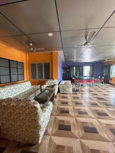 Cette grande chambre comprend des canapés, une table et des chaises. dans l'établissement Roop Amrit Guest House , Agartala, à Agartala