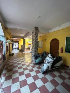 a room with a motorcycle parked in a room with a checkered floor at Roop Amrit Guest House , Agartala in Agartala