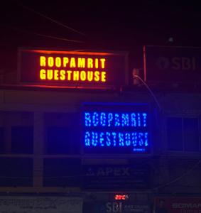 een neonbord dat een vragenlijst van saysrocommunit op een gebouw bevat bij Roop Amrit Guest House , Agartala in Agartala