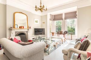 a living room with two couches and a fireplace at Garth Lodge with Tennis Court and Pool in Wimborne Minster