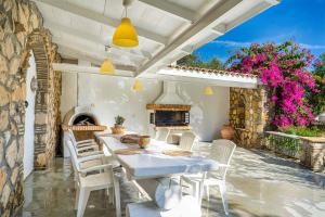 a patio with a table and chairs and a fireplace at Villa Archontiko in Makris Gialos