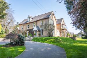 a large house with a driveway in front of it at Garth Lodge with Tennis Court and Pool in Wimborne Minster