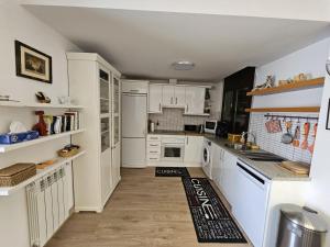 a kitchen with white cabinets and white appliances at Altissim Tarter - Inclès - Ransol in Sant Pere
