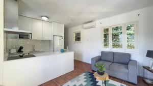 een woonkamer met een bank en een keuken bij Casa Varanda das Furnas in Furnas +21 foto's