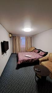 een hotelkamer met 2 bedden en een bank bij 2-х комнатная Квартира возле Солнечной галлереи in Yekaterinovka