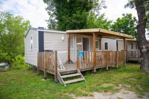 una casa pequeña con porche y terraza en Camping Parc Bellevue, en Cannes