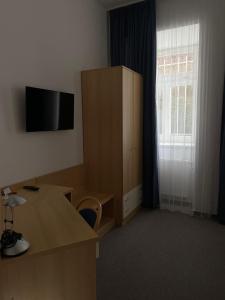 a room with a desk and a cabinet and a window at Hotel Pod Zámkem in Boskovice