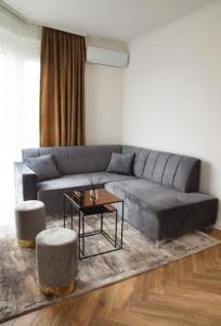 un soggiorno con divano grigio e tavolo di 6 DOC Dream Apartment 6 +Parcare a Oradea