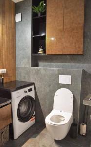 a bathroom with a toilet and a washing machine at 6 DOC Dream Apartment 6 +Parcare in Oradea