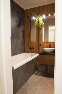 a bathroom with a bath tub and a sink at 6 DOC Dream Apartment 6 +Parcare in Oradea