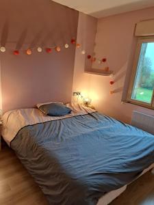 un letto grande in una camera da letto con finestra di Maison en colombage rénovée a La Fontenelle