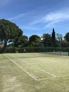 a tennis court with a person standing on it at top floor apartment with private park in Montpellier