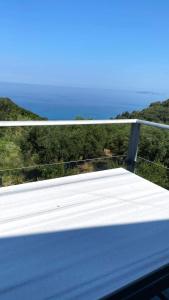 a white balcony with a view of the ocean at Amazing seaview apartment in Avliotes village Corfu in Avliótai