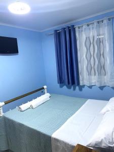 a blue room with a bed and a window at Amazing seaview apartment in Avliotes village Corfu in Avliótai