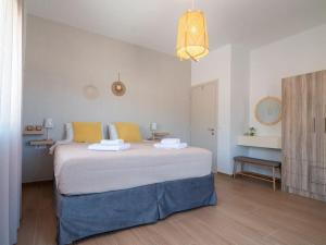 a bedroom with a large white bed with yellow pillows at Villa Helia by Smaris Collection in MALIA in Kartsindanós +27 photos