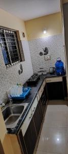 cocina con fregadero y encimera en ROSHAN STAYs, en Bangalore