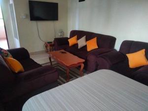 a living room with two couches and a table at Sun Set Paradise Baringo 11 in Mombasa