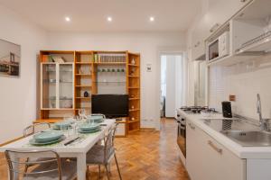 eine Küche mit einem Tisch mit Stühlen und einer Arbeitsplatte in der Unterkunft Palladio due - spazioso 3 camere in Triest