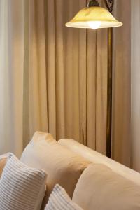 a lamp sitting next to a bed in a room at Luxus-Apartment im Sternenhof in Großkarlbach