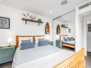 a bedroom with a large bed with blue and white pillows at Pass the Keys The Southside - Stylish Apartment with Private Terraces near Barnes & Putney in London