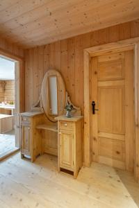 ein Holzbadezimmer mit einem Spiegel und einem Waschbecken in der Unterkunft Berghof Ferienhaus in Schröcken