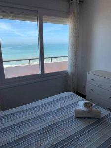 a bedroom with a bed with a view of the beach at El Mirador de la Playa Cortadura Grupo AC Gestion in Cádiz