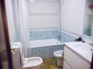a bathroom with a tub and a toilet and a sink at El Mirador de la Playa Cortadura Grupo AC Gestion in Cádiz