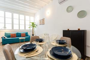 a dining room with a table and a blue couch at Tierra & Mar Ascensor Grupo AC Gestion in Cádiz