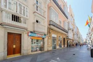 カディスにあるTierra & Mar Ascensor Grupo AC Gestionの通りに建築物や商店が並ぶ街道