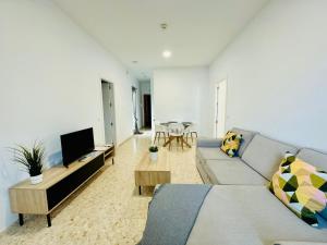 ein Wohnzimmer mit einem Sofa und einem Tisch in der Unterkunft La Muralla Playa y Ascensor Grupo AC Gestion in Cádiz