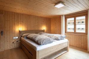 a bedroom with a bed in a wooden wall at Berghof Ferienhaus in Schröcken