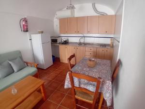 eine kleine Küche mit einem Tisch und einem Sofa in der Unterkunft Cuevas El Lago de Castilléjar in Castilléjar