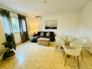 a living room with a glass table and a couch at La Muralla Playa y Ascensor Grupo AC Gestion in Cádiz