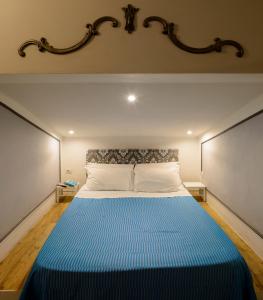 a bedroom with a large bed with a blue blanket at Donna Nobile in San Gimignano