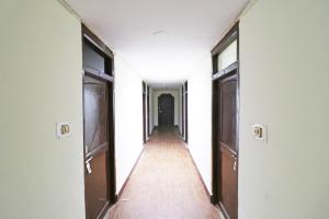 an empty hallway with two doors and a wooden floor at OYO Flagship Hotel Shreya in Bhubaneshwar