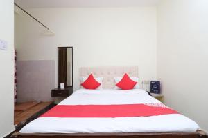 a bedroom with a large white bed with red pillows at OYO Flagship Hotel Shreya in Bhubaneshwar