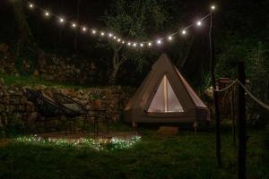 Chiusanico的住宿－Tipì - Glamping Experience，院子里的帐篷,晚上有灯