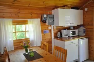 uma cozinha com uma mesa e um frigorífico em Sonfjällscampen em Hede