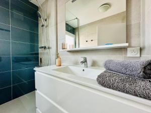 een badkamer met een wastafel en een spiegel bij Charmant appartement rénové 6 personnes les Sables in Les Sables-dʼOlonne