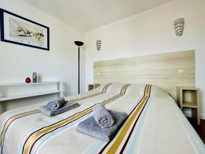 een slaapkamer met een groot bed en handdoeken bij Charmant appartement rénové 6 personnes les Sables in Les Sables-dʼOlonne