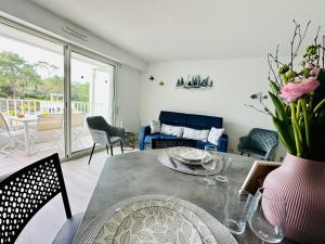 een woonkamer met een tafel met een vaas met bloemen bij Charmant appartement rénové 6 personnes les Sables in Les Sables-dʼOlonne