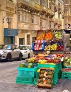 a fruit and vegetable stand on a city street at City Penthouse with roof terrace and sea views in Valletta