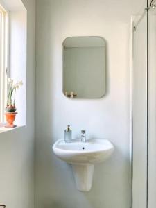 a bathroom with a white sink and a mirror at City Penthouse with roof terrace and sea views in Valletta