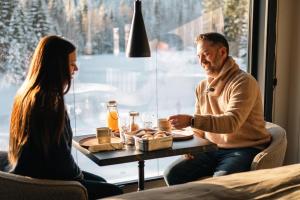 un hombre y una mujer sentados en una mesa con comida en Ådalsvollen retreat, en Verdal