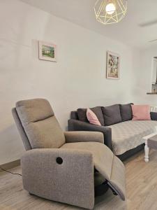 een woonkamer met een bank en een stoel bij House with 4 pools, Next to Beach in Gran Alacant