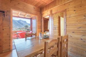 comedor de madera con mesa y ventana en Cabaña Madera A, en Bárig