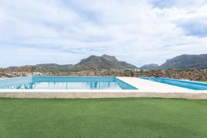 une piscine vide avec des montagnes en arrière-plan dans l'établissement Cabaña Madera A, à Bárig