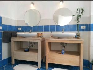 a bathroom with two sinks and two mirrors at Message in a Bottle Bed and Breakfast in Camporosso