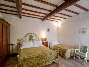 sypialnia z dwoma łóżkami i krzesłem w obiekcie Donna Nobile w mieście San Gimignano